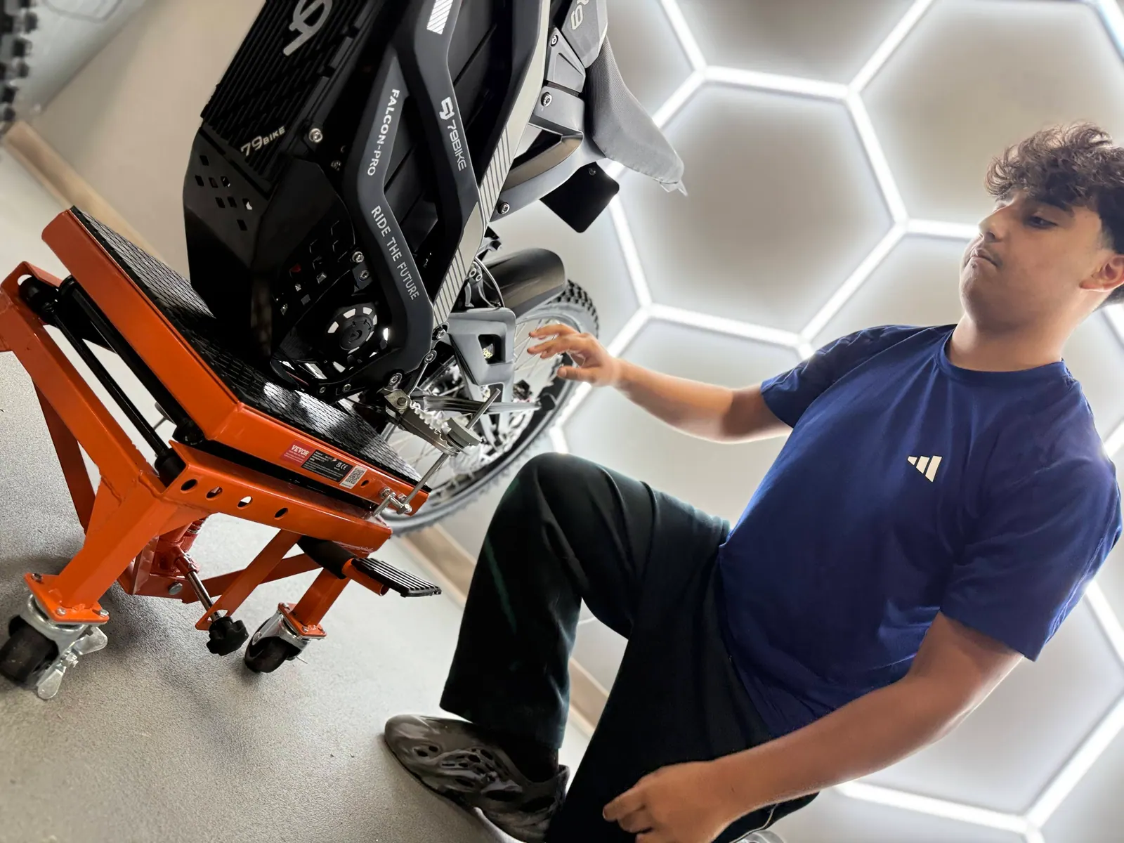 VoltRush USA team member inspecting an electric dirt bike