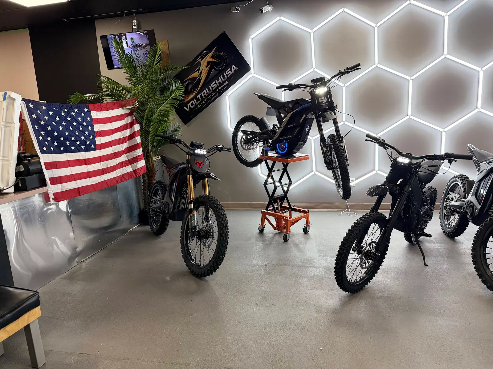 Electric dirt bikes and American flag inside the VoltRush USA showroom