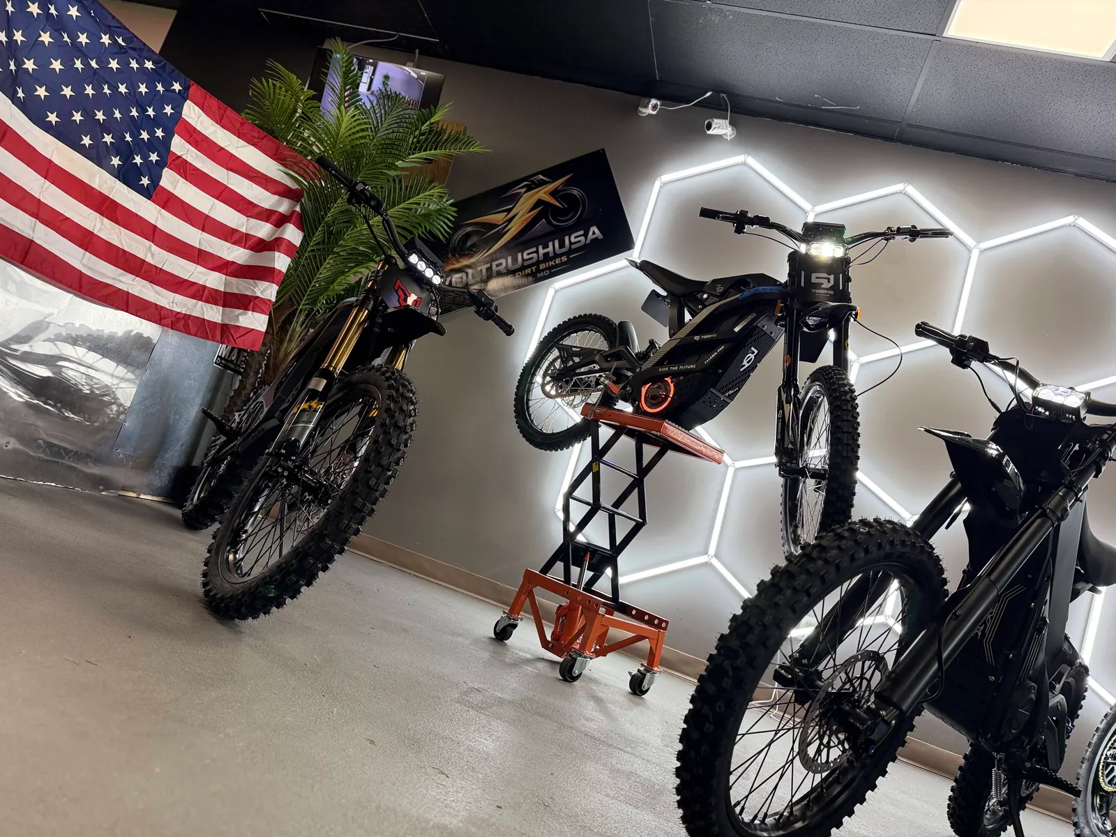 Electric dirt bikes displayed with an American flag inside the VoltRush USA showroom